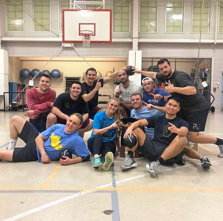 A group of students posing in front of a basketball hoop in the Finley Recreation Center